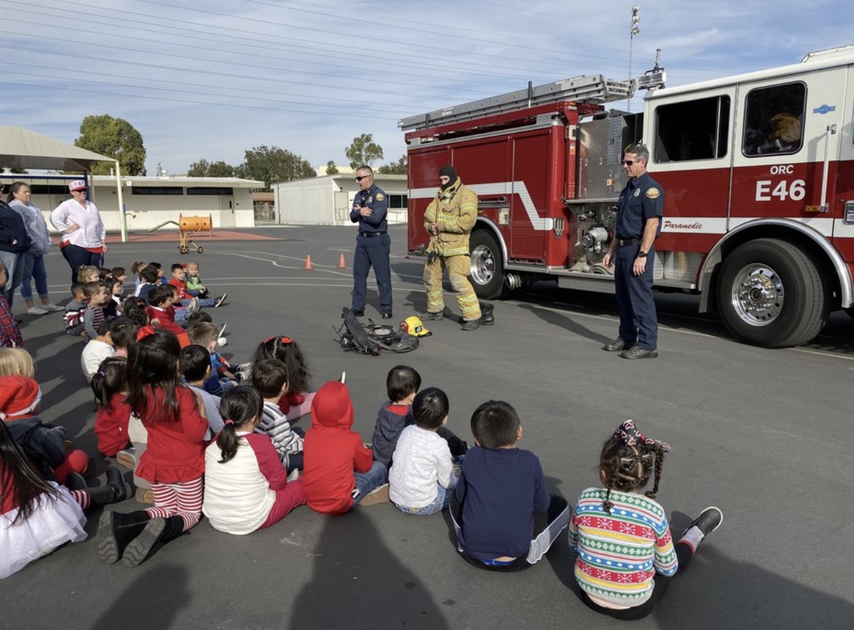 Firemen showing the students protective gear.