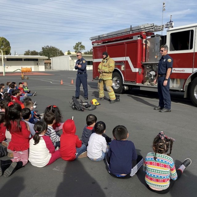 Firemen showing the students protective gear.